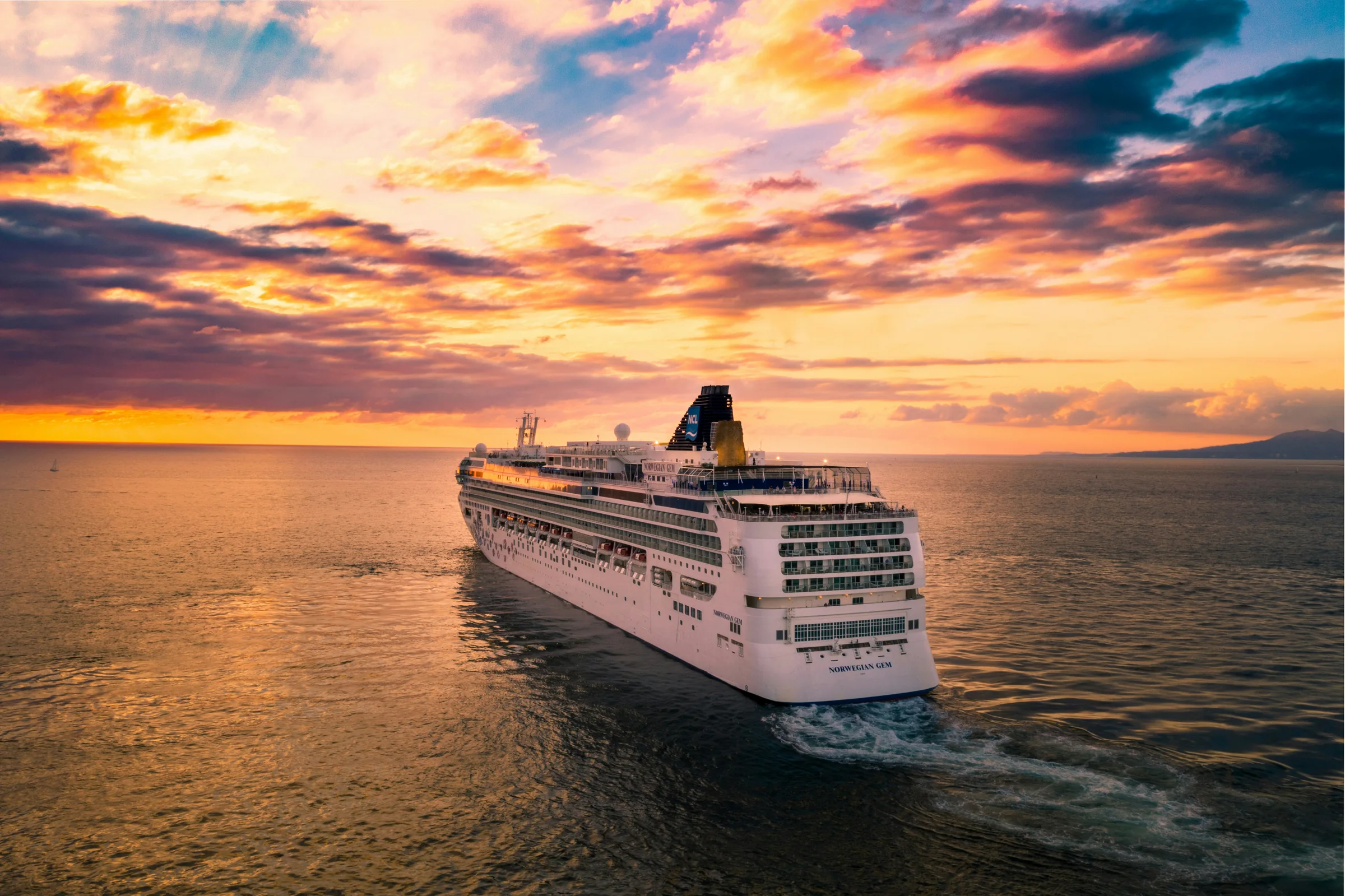 Cruise ship at sunset sailing at sea