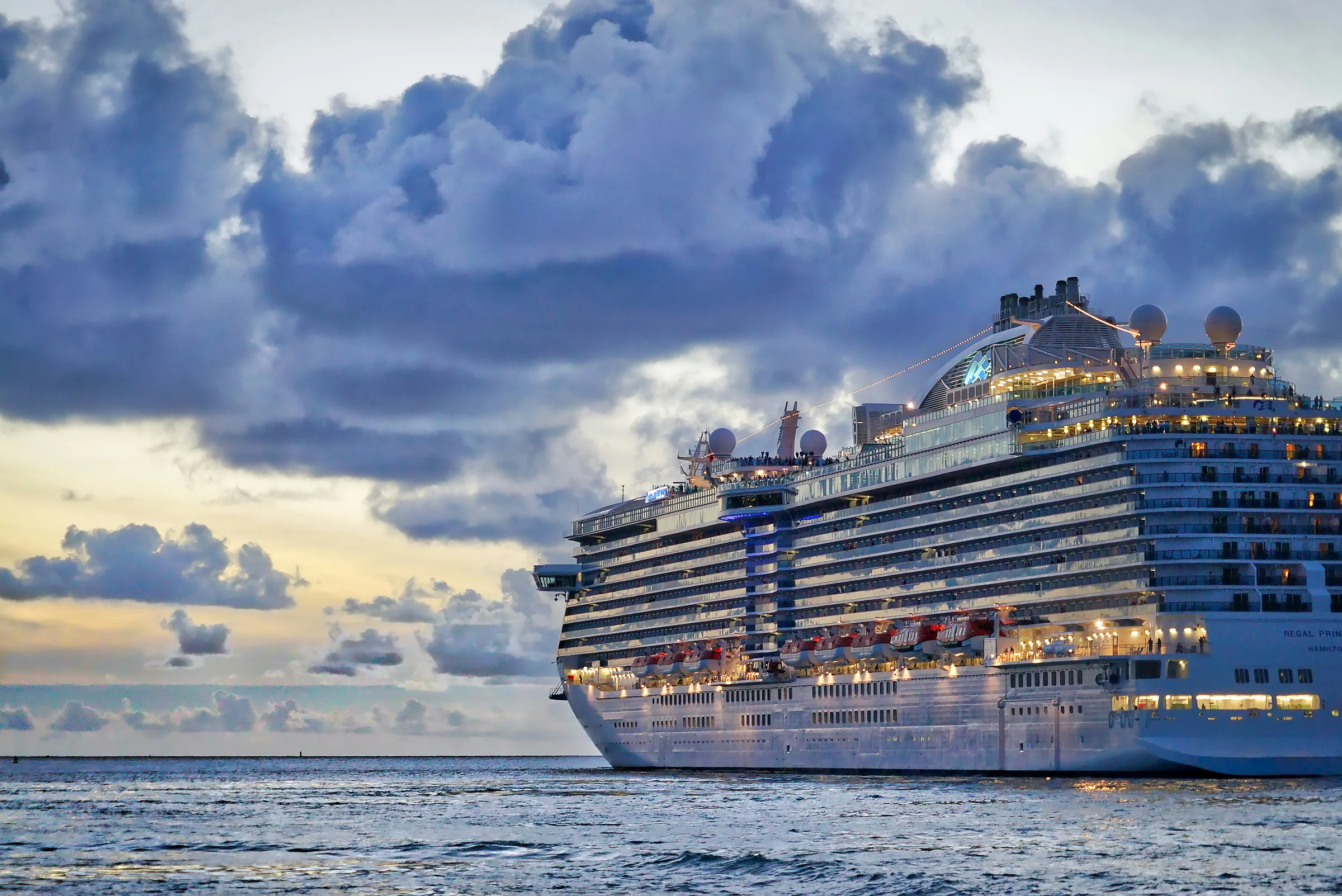 Cruise ship sailing beneath evening clouds